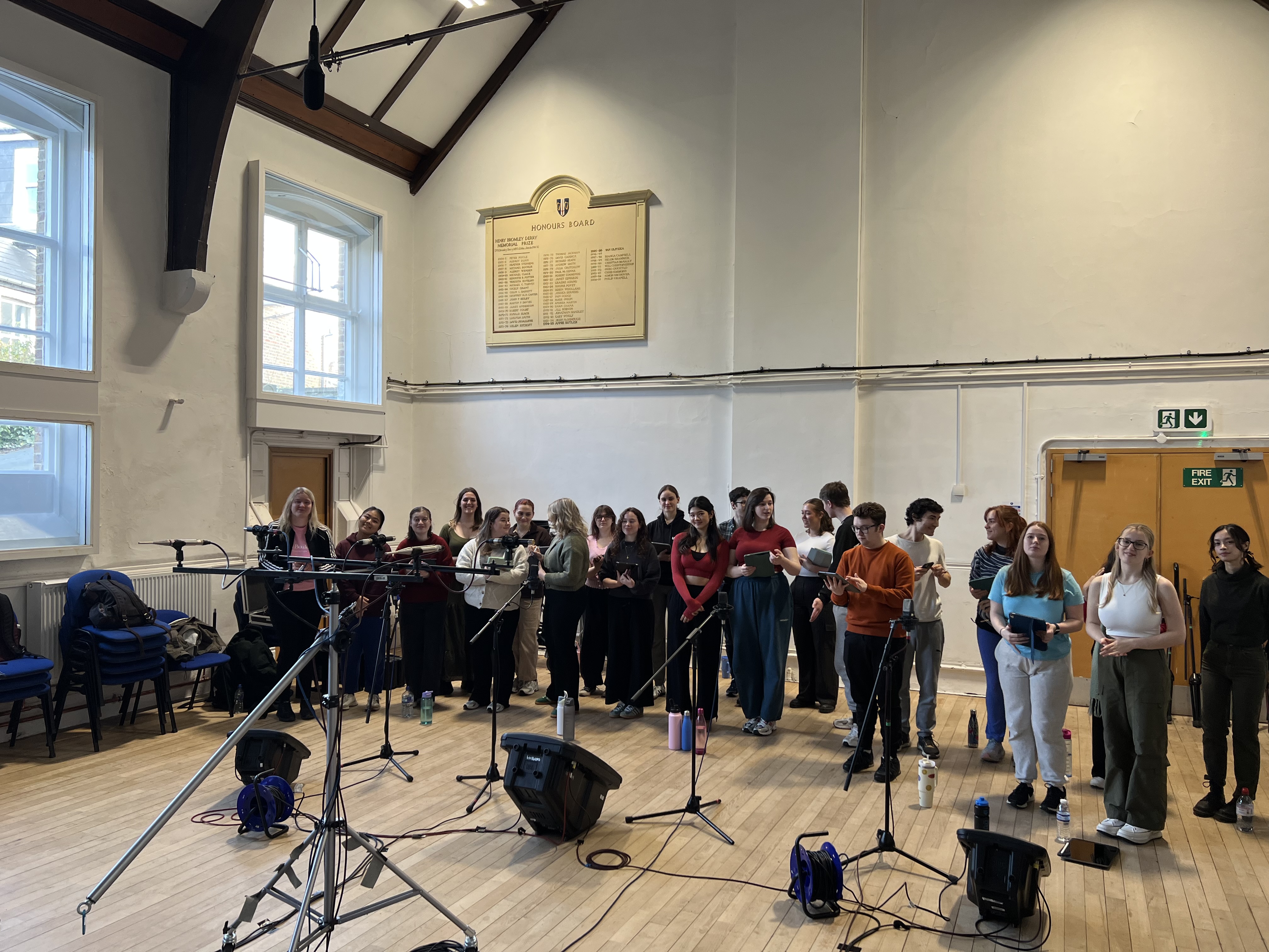 A choir stood in front of wedge monitors and microphones. 